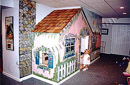 This finished basement in Chester County, PA has a play house built under the stairs which is painted to look like a cottage and has real cedar shingles. 